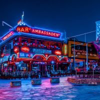 Lively bar in Ayia Napa with colorful lighting, people enjoying drinks, and a vibrant nightlife atmosphere.